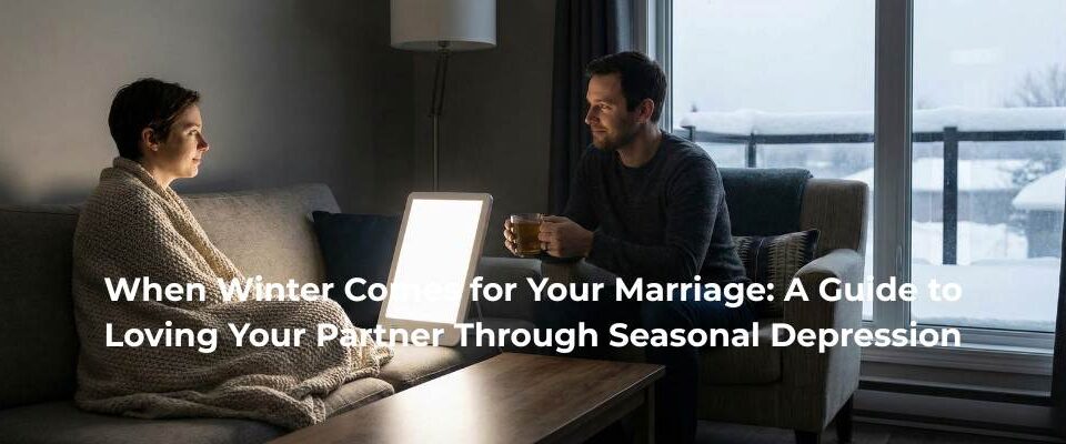 A supportive husband sits with his wife who is wrapped in a blanket and using a light therapy lamp for Seasonal Affective Disorder (SAD) on a snowy winter day.